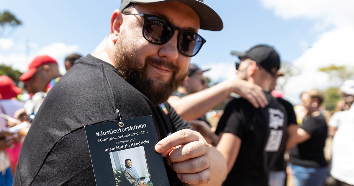 A photo of a man at Cape Town Pride wearing a #JusticeForMuhsin badge on his shoulder in memory of murdered gay Imam Muhsin Hendricks.